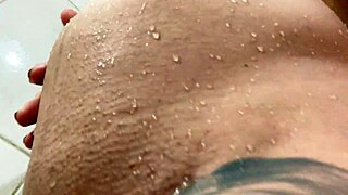 Își arată corpul gol gravid în duș în timp ce se rade.