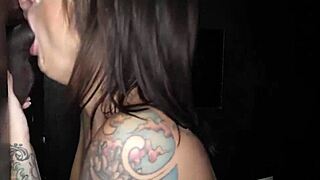 Brunette inked milf swallows cum at gloryhole