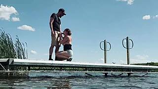 Couple risks getting caught fucking outdoors at the lake. They expose big natural tits and perform blowjob for anyone to watch.