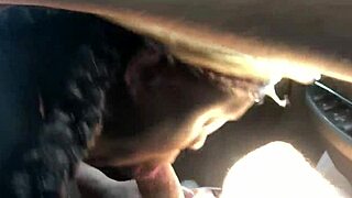 Black hooker slurps white cock in car.