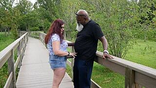 Nerdowata MILF głaszcze dużego czarnego kutasa w parku, błyskając okularami, interracial